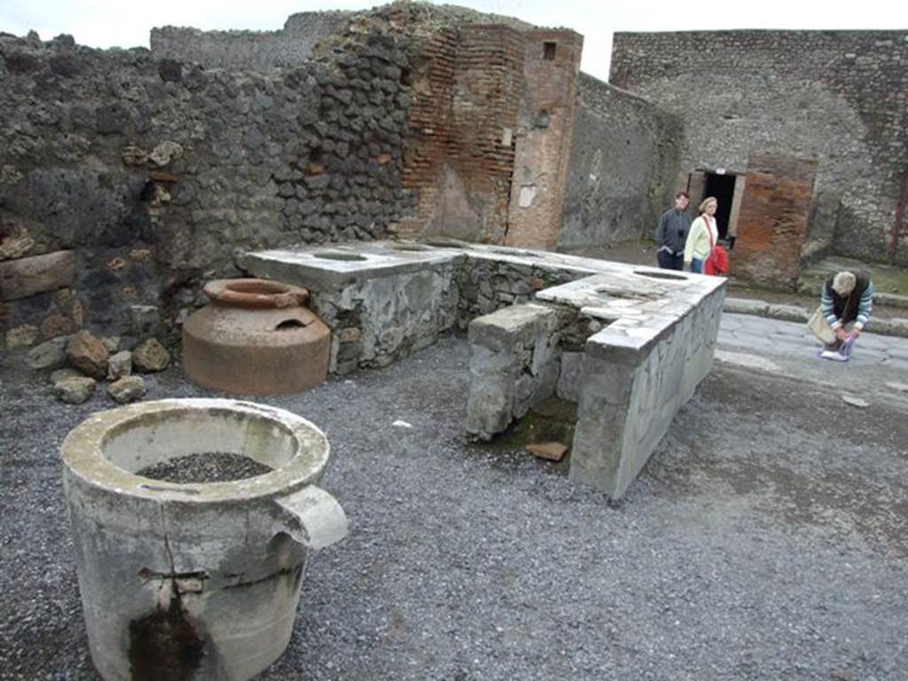 VI.8.8 Pompeii. March 2009.  Rear of counter on east side, with remains of hearth and dolium.
