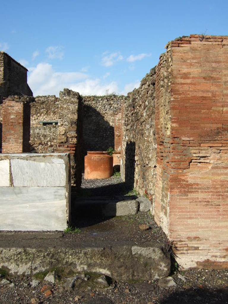 VI.8.10 Pompeii. December 2005. Looking north. According to Garcia y Garcia, there used to be a small pilaster that divided entrance 9 and 10, on the left in front of the counter. In 1943 a bomb fell on the road here, causing the destruction and loss of the pilaster. See Garcia y Garcia, L., 2006. Danni di guerra a Pompei. Rome: L’Erma di Bretschneider, (p.76).
According to Pagano and Prisciandaro, in March and April 1824 somewhere along the walls of the entrance 9 and 10, were found –
M(arcum) Cerrinium aed(ilem)
d(ignum) r(ei) p(ublicae) o(ro) v(os) f(aciatis) di<g=C>(nus) <e=I>s(t)    [CIL IV 264]
Licinium Faust(um)    [CIL IV 265]
written under, in red -  M(arcum) Cerrinium    [CIL IV 266]
Q(uintum) Postumium    [CIL IV 267]
L(ucium) Ceium
Secundum    [CIL IV 268]
See Pagano, M. and Prisciandaro, R., 2006. Studio sulle provenienze degli oggetti rinvenuti negli scavi borbonici del regno di Napoli.  Naples : Nicola Longobardi. (p. 129)  See PAH II,100; III, 50
