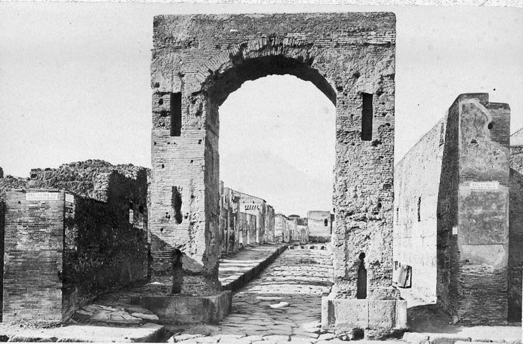 VI.8.11 Pompeii, front and side wall, on left of picture.
Looking north through Arch of Caligula along Via di Mercurio. About 1870. Photo courtesy of Rick Bauer.
According to Pagano and Prisciandaro, graffiti were found on these walls in 1824.
Found on the wall to the left of the arch was –

Hypsaeum
quinq(uennalem) d(ignum) r(ei) p(ublicae)    [CIL IV 270]

C(aium) Iulium Polybium
d(uumvirum) i(ure) d(icundo) o(ro) v(os) f(aciatis)    [CIL IV 271]

M(arcum) Lucretium [F]ro[ntonem]    [CIL IV 272]

See Pagano, M. and Prisciandaro, R., 2006. Studio sulle provenienze degli oggetti rinvenuti negli scavi borbonici del regno di Napoli. Naples: Nicola Longobardi, (p.128)
See Fiorelli G., 1862. Pompeianarum antiquitatum historia, Vol. 2: 1819 – 1860. Naples, p. 91.
See Fiorelli G., 1864. Pompeianarum antiquitatum historia, Vol. 3. Naples, p. 47.
