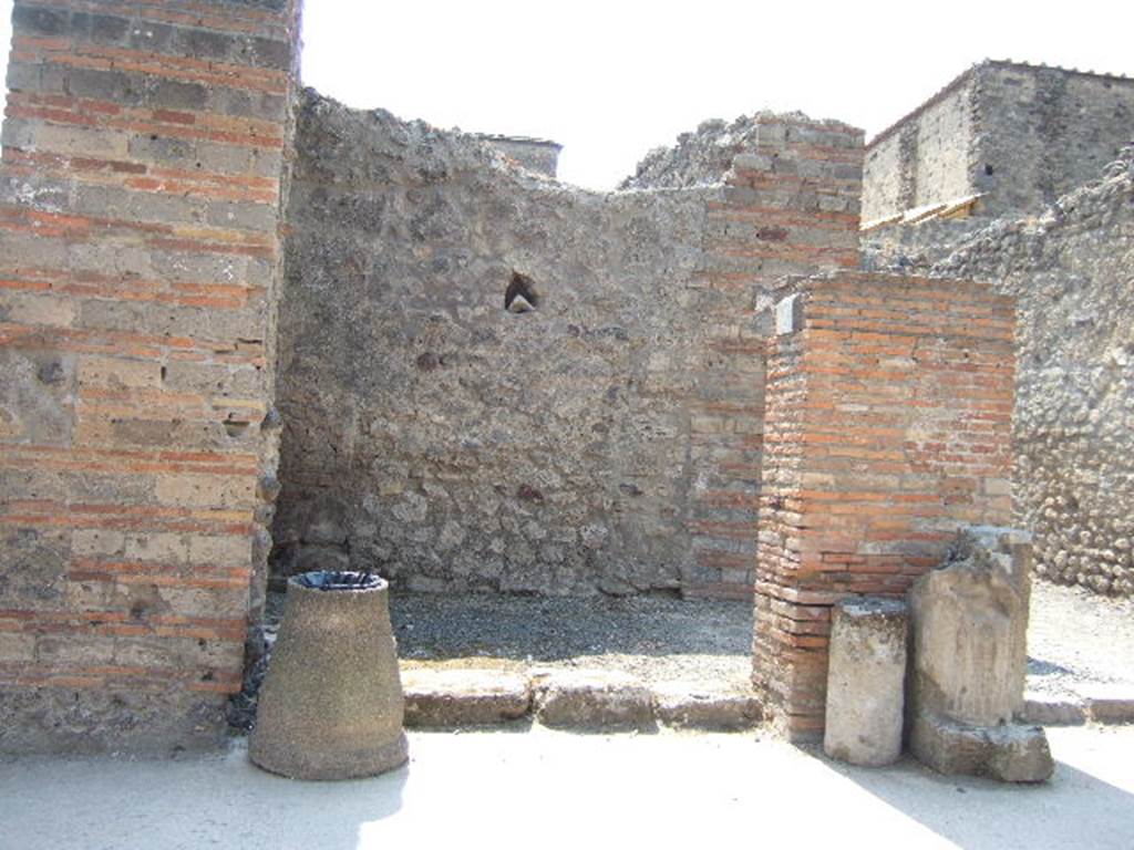 VI.8.12 Pompeii. May 2006. Looking west to entrance doorway.
According to Della Corte, on the left of entrance number 12 was found an electoral recommendation from the Pomari (the fruitsellers)–
Pomari rog(ant) [CIL IV 180].
Between the entrances of VI.8.12 and 13 was found –
Pomari facite     [CIL IV 183], and then opposite this third, was found –
Pomari rog(ant)    [CIL IV 149]
A fourth recommendation could be read on the exterior of the House of Helvio Vestale (VI.8.22/1)–
Pomari rog(ant)    [CIL IV 206]      and also near this last was found –
Pomari universi
Cum Helvio Vestale rog(ant)    [CIL IV 202]
Della Corte’s theory was that this all proved that Helvius Vestalis was the protector, the head of the collegium of fruitsellers of Pompeii, and that the meetings of the society were perhaps held in the upper rooms of number 12 and 13.  See Della Corte, M., 1965.  Case ed Abitanti di Pompei. Napoli: Fausto Fiorentino. (p.59)
According to Epigraphik-Datenbank Clauss/Slaby (See www.manfredclauss.de), these read as –
M(arcum) Enium Sabinum 
aed(ilem) pomari rog(ant)      [CIL IV 180]
Vettium Firmum
aed(ilem) o(ro) v(os) f(aciatis) dign(um)
est pomari facite                      [CIL IV 183]
M(arcum) Cerrinium
aed(ilem) pomari rog(ant)      [CIL IV 149]
M(arcum) Holconium
Priscum aed(ilem) pomari rog(ant)      [CIL IV 206]
M(arcum) Holconium
Priscum IIvir(um) i(ure) d(icundo)
pomari universi
cum Helvio Vestale rog(ant)     [CIL IV 202]
According to Pagano and Prisciandaro, found in July 1825 written on the wall on the left, was –
Marcellum aediles
et Albucium
o(ro) v(os) f(aciatis)    [CIL IV 182]
and in September 1825, found written in red, were –
Faustinium    [CIL IV 185]
L(ucium) Albucium    [CIL IV 186]
and in February 1826, found painted in red, on the pilaster between 12 and 13, was –
M(arcum) Albucium aed(ilem)    [CIL IV 184]
See Pagano, M. and Prisciandaro, R., 2006. Studio sulle provenienze degli oggetti rinvenuti negli scavi borbonici del regno di Napoli.  Naples : Nicola Longobardi. (p. 133-4)   PAH II, 135,  PAH II, 148.
