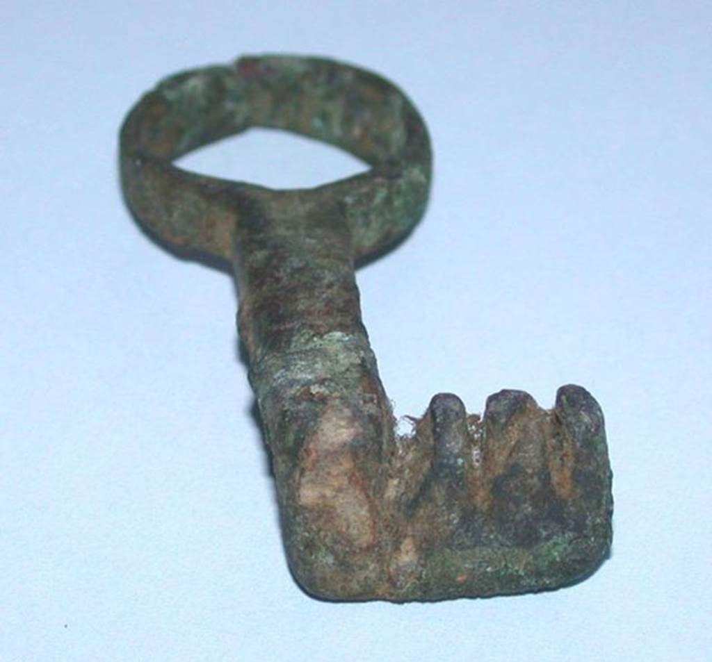 VI.9.1 Bronze key with three teeth, side 1.   Length 0.05m.  OA 2025 Clef, muse Cond, photo RMN  R.G. Ojeda