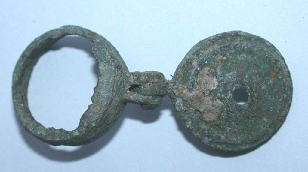 VI.9.1 Small bronze object with a mortise and a pin with a circular element whose bottom is torn off. Side 2. Height 0.008m, diameter 0.016m.  OA 2030 Petit lment articul, muse Cond, photo RMN  R.G. Ojeda