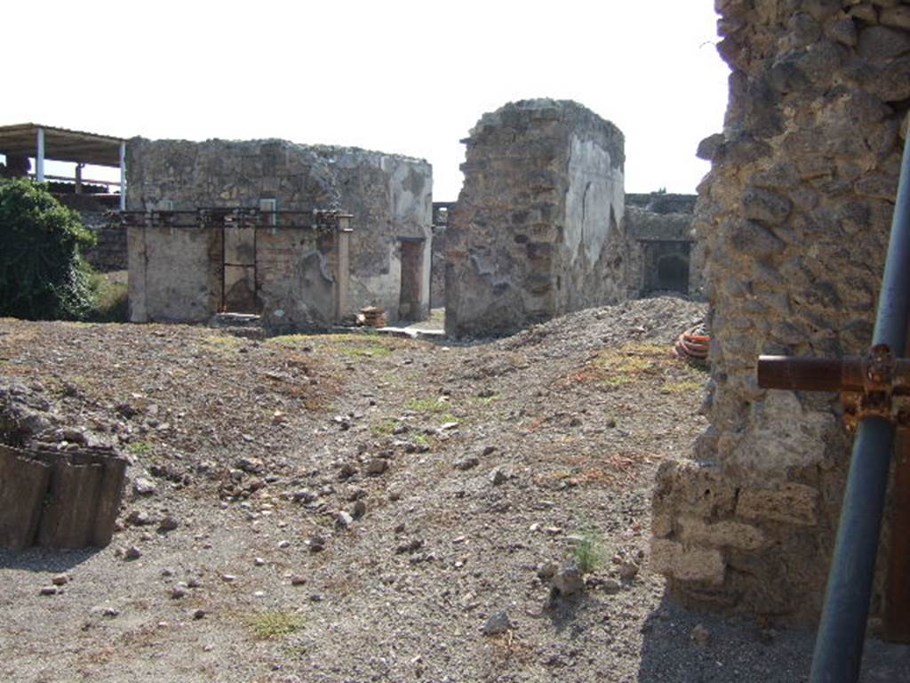 VI.9.12 Pompeii. September 2005. Looking west from gap in rear wall towards rooms 32, 28, tablinum 26, and triclinium 27 of VI.9.5, across area 30.
