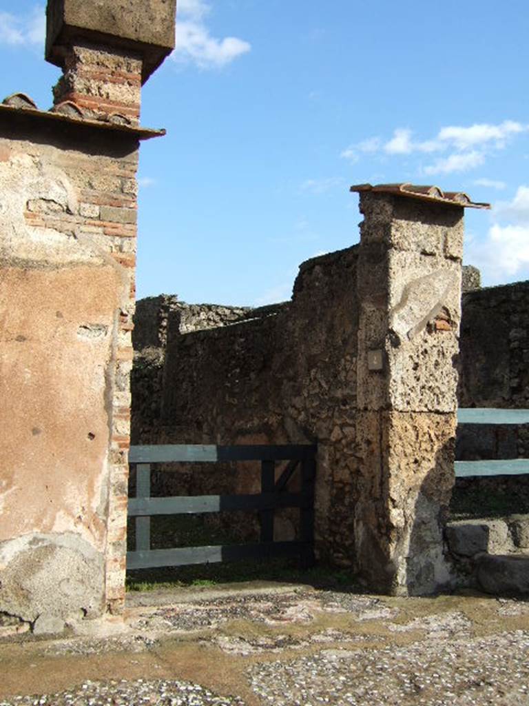 VI.10.4 Pompeii. December 2005. Entrance doorway.
According to Leach, a respectable tavern couple, Caprasia and Nymphius, supported the campaign of their down-the-street neighbours the Vettii. She said that given that Caprasia’s name showed a family affiliation with Vettius’s adoptive son Caprasius, the connection drew her attention to the social dynamics of the neighbourhood. See Leach, E.W: The Social Life of Painting in Ancient Rome and on the Bay of Naples.
According to Della Corte, Caprasia lived on this insula, together with Nymphius, perhaps her husband.  They ran the caupona at number 3, from the front of the dwelling at number 4. A written recommendation was found on the pilaster between 6 and 7 -  Caprasia cum Nymphio rog(at) una et vicini   [CIL IV 171] See Della Corte, M., 1965.  Case ed Abitanti di Pompei. Napoli: Fausto Fiorentino. (p.55)

According to Epigraphik-Datenbank Clauss/Slaby (See www.manfredclauss.de), this read as –

A(ulum) Vettium Firmum 
aed(ilem) o(ro) v(os) f(aciatis) dign(um) est 
una et vicini o(ro) v(os) f(aciatis)             [CIL IV 171]

According to Coarelli and Pesando, CIL IV 171 reads as –
A VETTIVM FIRMVM 
AED O V F DIGN EST 
CAPRASIA CVM NYMPHIO ROG
VNA ET VICINI O V F

See Coarelli, F. and Pesando, F. (a cura di), 2006. Rileggere Pompei, Volume 1: L’insula 10 della Regio VI. Roma: L’Erma di Bretschneider. (p. 106-7).
