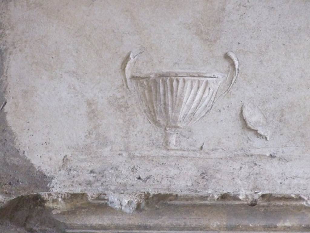 VI.11.9 Pompeii. December 2006. Room 21, detail in stucco of urn or cup on south end in arch of tepidarium.
