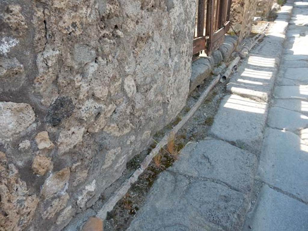 VI.13.13 Pompeii. May 2015. Vicolo dei Vettii outside entrance doorway, showing lead pipes in pavement. Photo courtesy of Buzz Ferebee.
