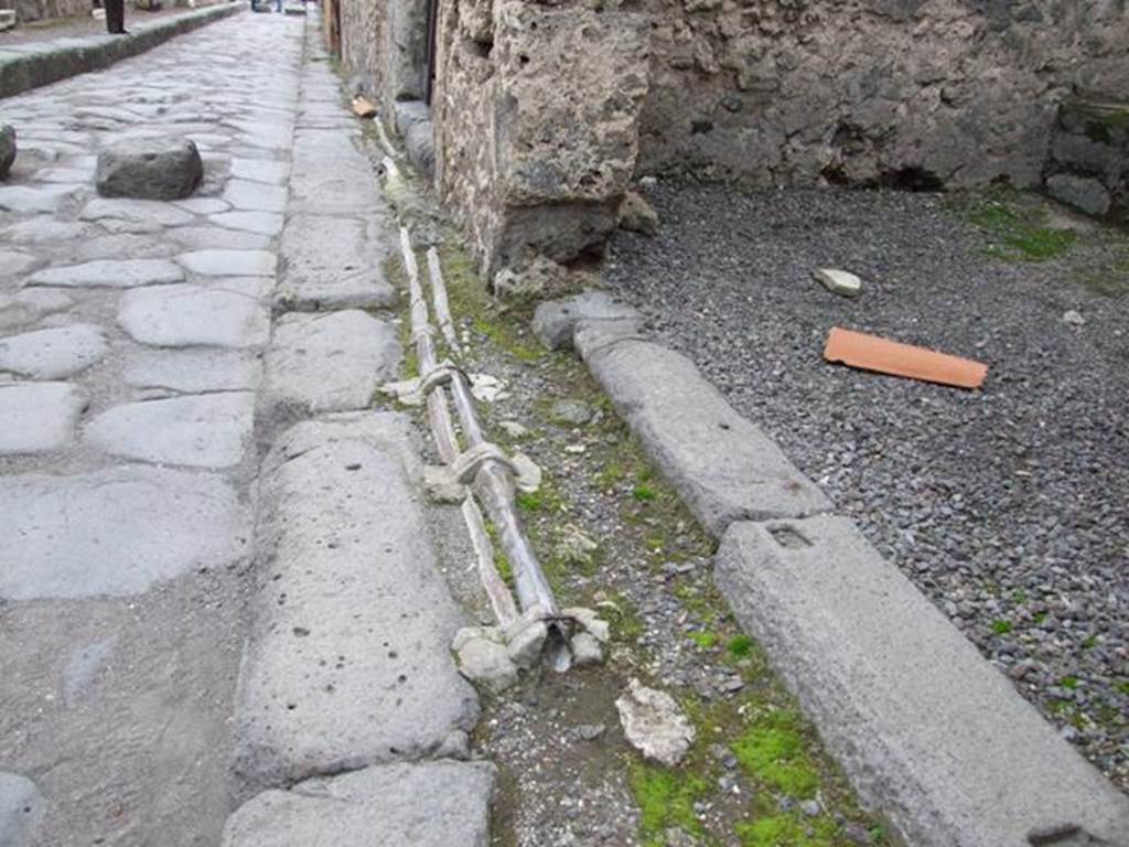 VI.13.14 Pompeii. December 2007. Pavement with lead pipes on Vicolo dei Vettii, looking south