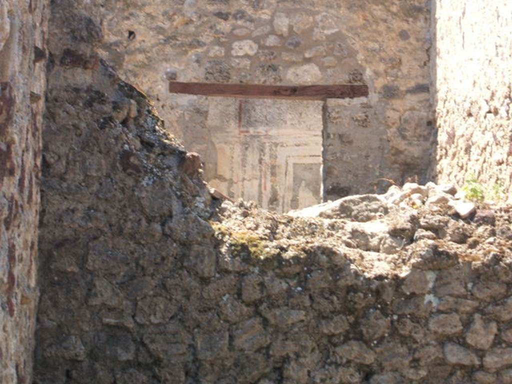 VI.14.25 Pompeii. May 2005. Fresco from VI.14.26 showing repaired wall/doorway, looking over rear wall from VI.14.25.

