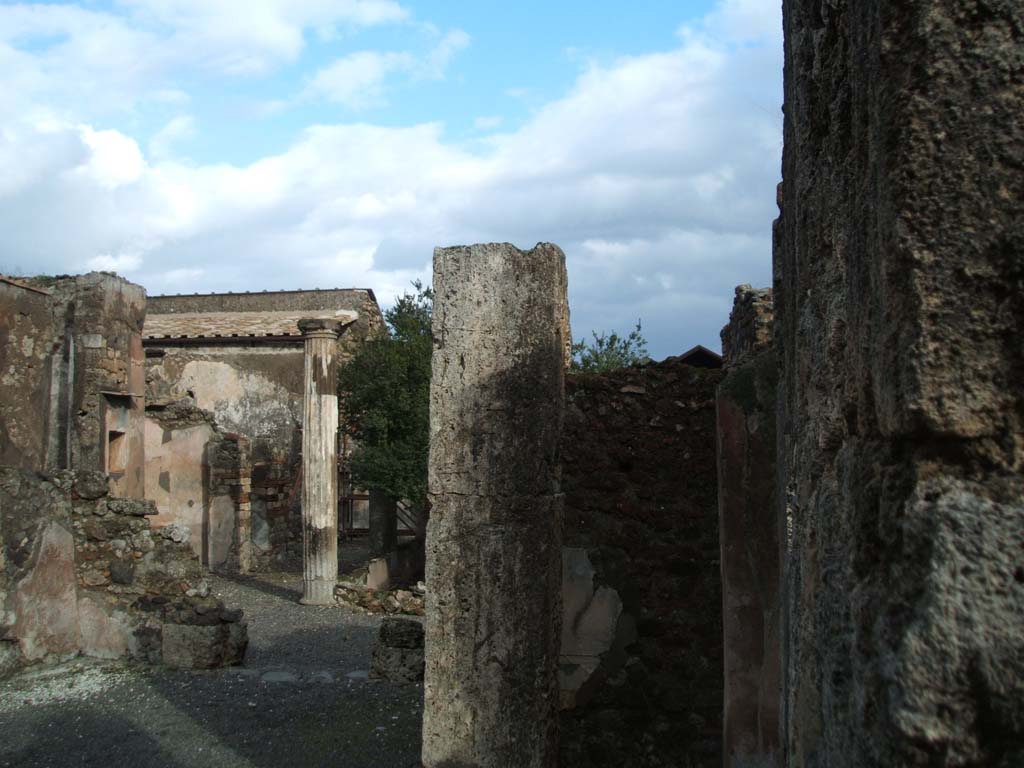 VI.14.43 Pompeii. December 2004. Looking east across atrium towards doorway to room 8, on right of centre. 
Room 7, (on left) looking through tablinum to west portico, and north side of rear of house.
According to Jashemski, the peristyle garden, excavated in 1839, entered by a corridor from the atrium, had walls decorated in the first style.
The portico which enclosed the garden on the north and part of the west sides was supported by four fluted columns joined by a low wall.
See Jashemski, W. F., 1993. The Gardens of Pompeii, Volume II: Appendices. New York: Caratzas. (p.151).

