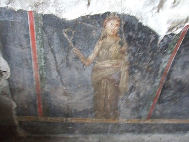 VI.15.1 Pompeii. October 2001. Detail from panel on west wall of painting of cupids buying and selling wine. Photo courtesy of Peter Woods.

