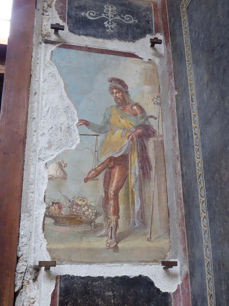 VI.15.1 Pompeii. May 2017. Detail from painting in vestibule, seeming to suggest good health is worth its weight in gold. A large basket of fruit represents the abundance of the house. Photo courtesy of Buzz Ferebee.
