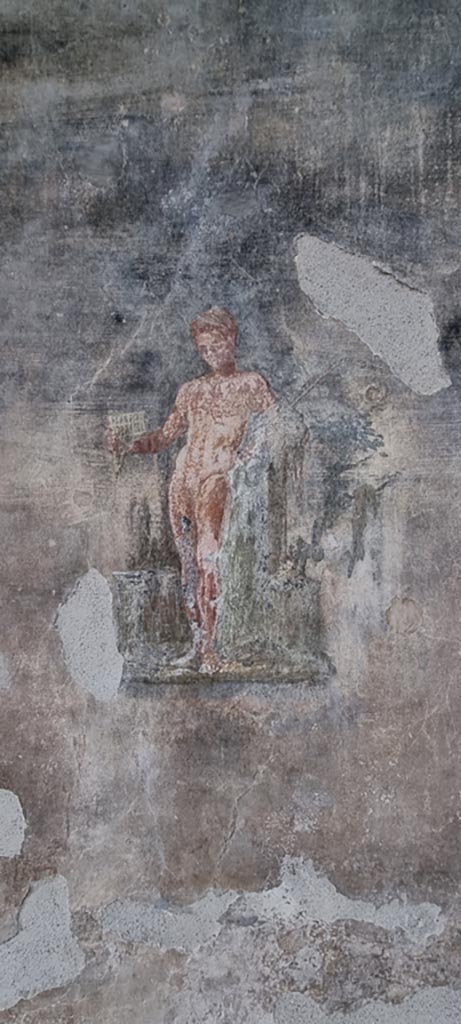 VI.15.1 Pompeii. January 2023. 
Painting of a young nude Satyr with pan-pipes held in his right hand, and thyrsus in his left, from west wall of peristyle. 
Photo courtesy of Miriam Colomer.

