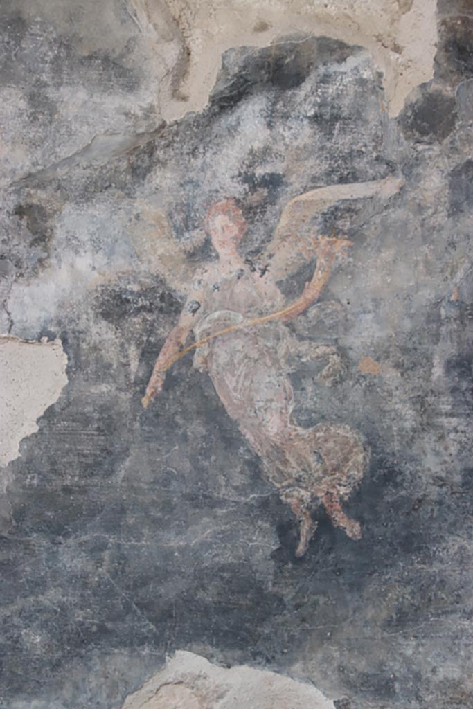 VI.15.1 Pompeii. October 2023. 
Painting of winged figure with cornucopia, from west wall of peristyle towards north end. 
Photo courtesy of Klaus Heese.
