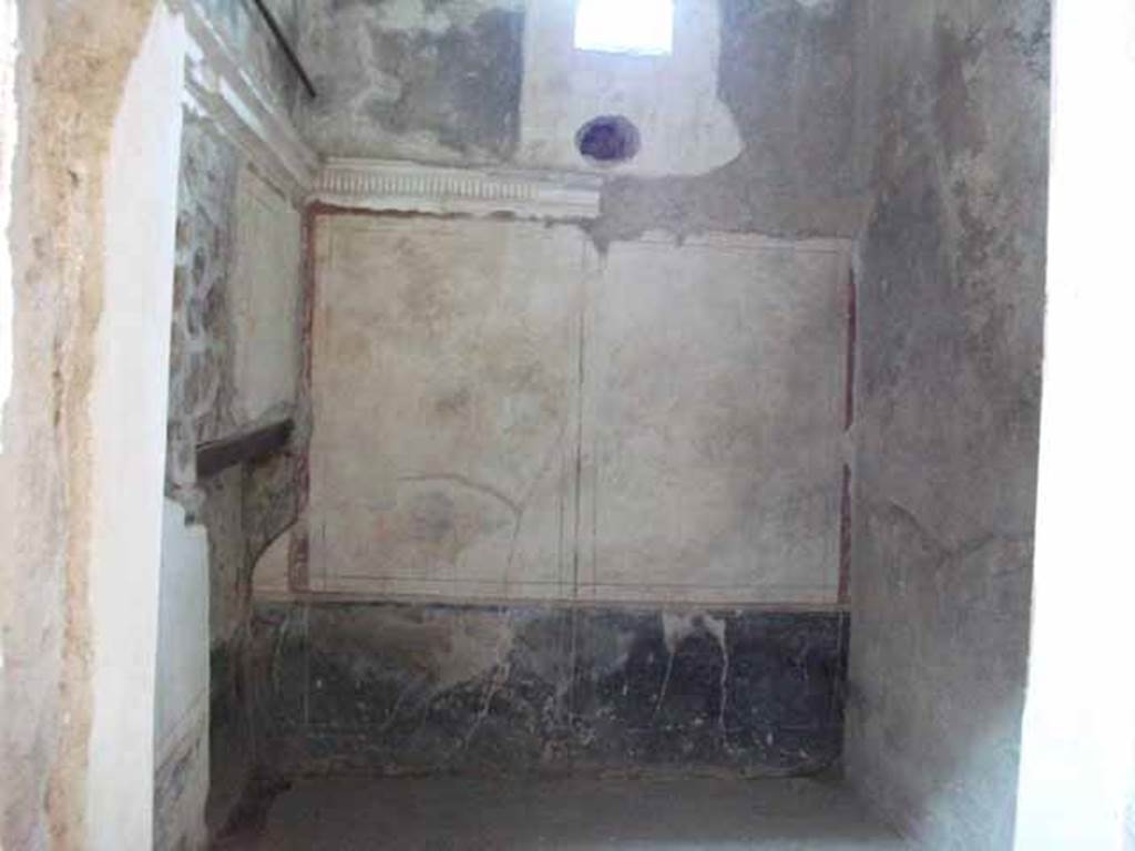 VI.15.8 Pompeii. May 2010. Looking through doorway in cubiculum on south side of entrance corridor.
Looking towards east wall of cubiculum with window onto Vicolo dei Vettii.
According to NdS, this room had been covered by a barrel-vaulted ceiling and had a recess for a bed.
The walls were decorated with a white background and had a stucco cornice which ran around the walls at a height of approximately 2m from the floor.
See Notizie degli Scavi di Antichità, January 1897, (p.34).

