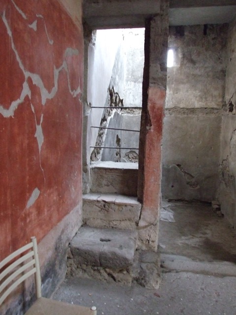VI.15.8 Pompeii. December 2007. Room to north of entrance with stone steps and remains of a staircase in the plasterwork on the north wall.
