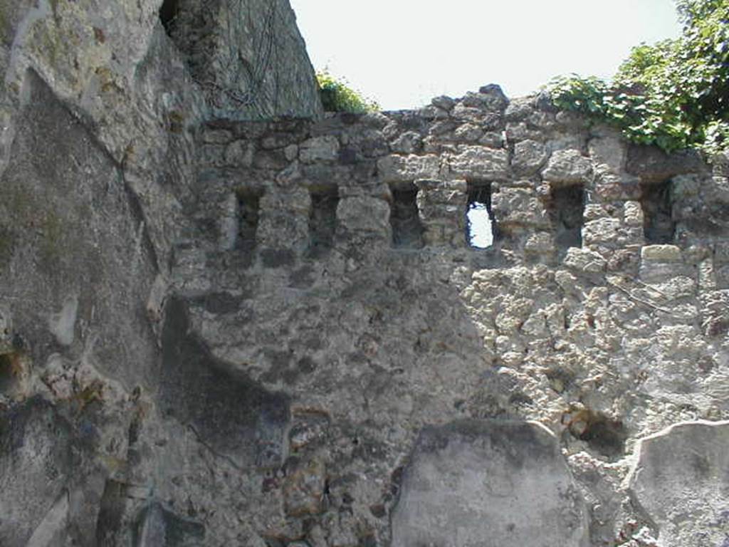 VI.15.10 Pompeii. May 2005. West wall with support holes for an upper floor.