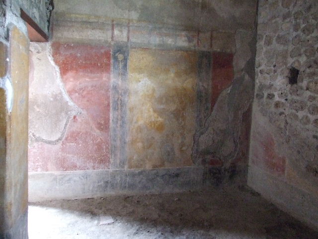 VI.16.15 Pompeii. December 2006. North wall of room H, with east wall on the right. Each wall was divided into three major panels, painted yellow in the centre with red at the sides.
The high frieze had a white background, and the lower dado was painted black. The eastern wall was entirely destroyed. See Notizie degli Scavi, 1908, (p.82)

   
