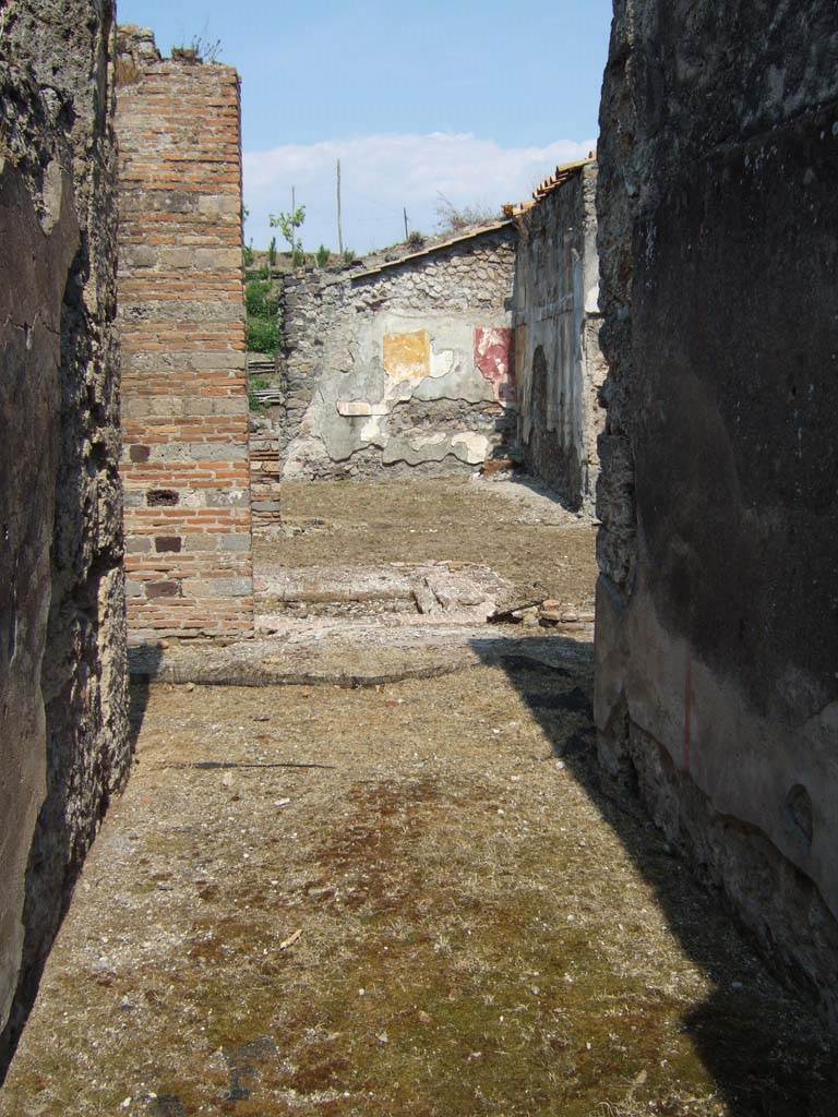 VI.16.26 Pompeii. May 2006. Looking east from entrance doorway across fauces A. According to NdS, this floor was made of opus signinum and sloped upwards from the doorway. The walls had a high plinth of plaster imitating a coarse decoration of marble, and above it was a simple rough plaster.
