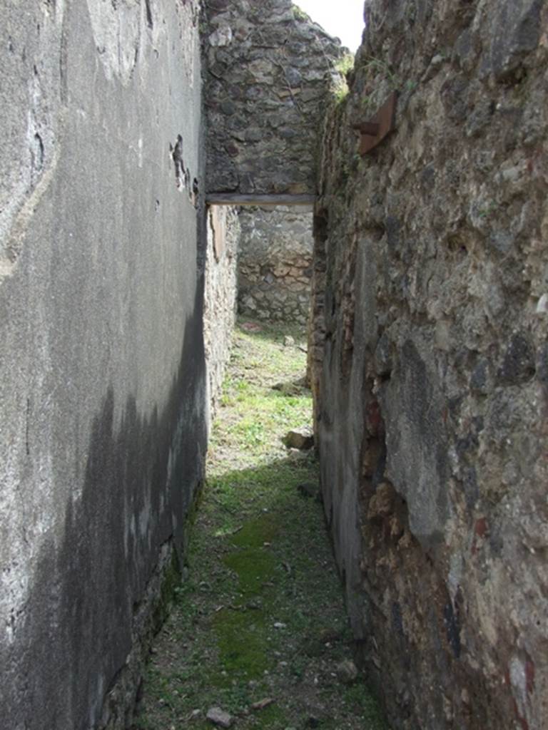 VI.16.27 Pompeii. March 2009. Corridor leading south towards rooms Y, Z and A’. According to NdS, this corridor ran south behind the west side of the peristyle. Its walls were similarly painted to the fauces, imitating slabs of marble with black and white vertical streaks.
