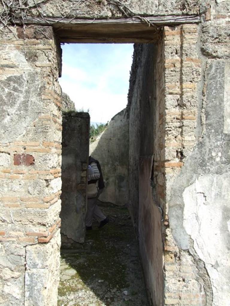 VI.16.28 Pompeii. March 2009. Doorway to rooms G and H. According to NdS, to the side of the tablinum were two rather narrow rooms, with lava threshold and showed remains of wood towards the atrium. The doorway on the left, which preserved in the threshold the two iron hinges, led into room G, which was a small rustic room. Its floor was made of cocciopesto, and had rough plaster on the walls, except on the south wall which formed a continuation from the atrium.  See Notizie degli Scavi di Antichità, 1908, (p.277)
