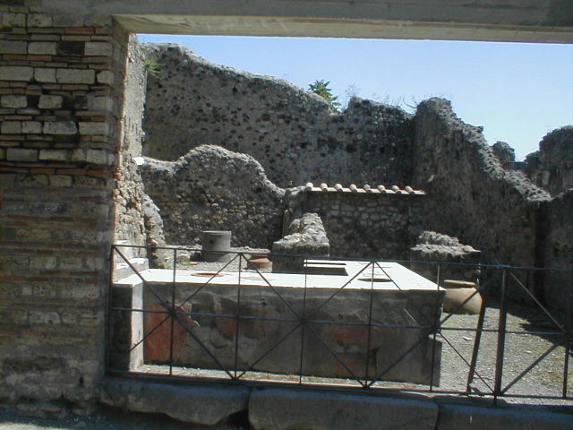 VI.16.40 Pompeii. May 2005. Looking east towards entrance doorway and room B. According to NdS, the wide doorway had a threshold made of three pieces of lava. It had the usual notches for the boards and the lowering to the right for the movable shutter. It seemed the doorposts were coated with plaster, painted red. See Notizie degli Scavi di Antichità, 1908, p.368-370.