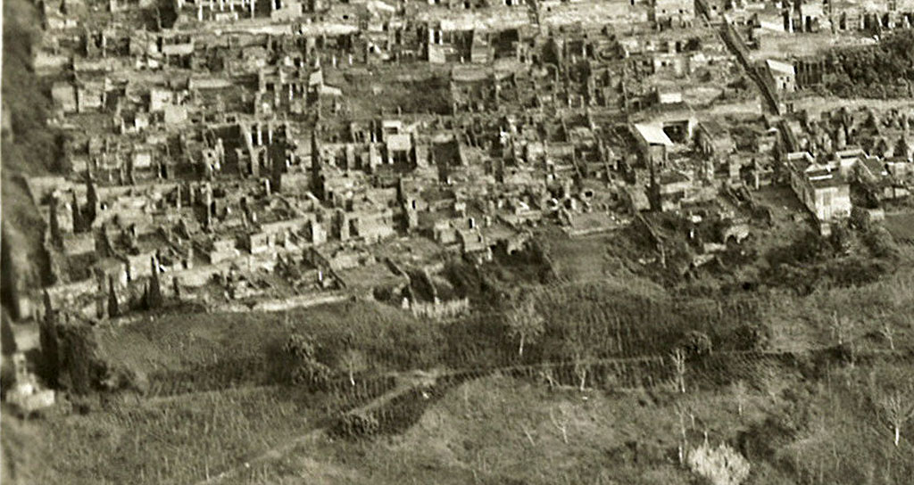 VI.17. 1 – 28, Insula Occidentalis, dated 9th January 1954, detail from RAF Aerial photo. Photo courtesy of Rick Bauer.
Starting from the right, the white reconstructed dwelling would be VI.17.27/8, House of the Skeletons, opposite the Vicolo di Mercurio.
On its left would be VI.17.25/26, opposite the House of Sallust, and next to that, on its left, would be the street level peristyle of VI.17.23, with a view of the remaining floors beneath, all part of the House of the Lion.
On its left, divided by a wall, front to back, would be VI.17.17/16, the House of C. Ceio.
On its left, another dividing wall would separate VI.17.13, the House of C. Nivillio
On its left would be VI.17.10/9, with some of the rear remaining floors underneath no.10, the House of the Danzatrice/of House of Diana I, opposite the House of the Surgeon.
Then there is the small house at VI.17.5, the House of Popidius Rufus
On the left of the photo is the rear of the area from VI.17.1/2/3/4. 
