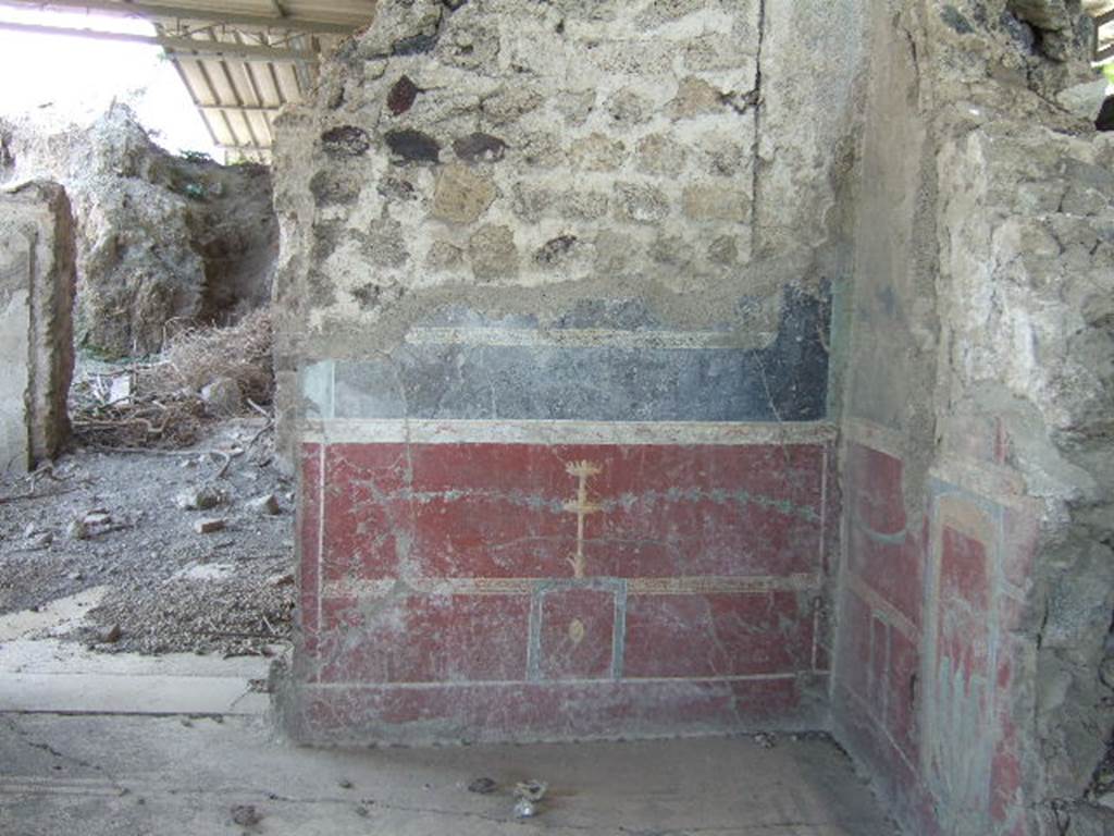 VI.17.36.Pompeii. May 2006. Taken from VI.17.41. East wall and doorway, looking towards south-east corner in eastern cubiculum (room “a”) of VI.17.36, on south side of peristyle.
According to PPP, the east wall had a red panelled zoccolo, in the central panel was an painted plate/medallion with a painted candelabra above it. The middle zone of the wall would have been black.



