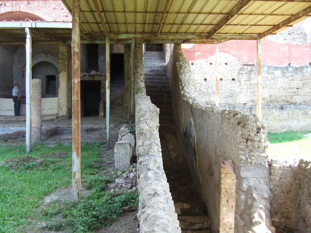 VI.17.42 Pompeii. May 2006. Garden, on left, and corridor and garden of VII.16.22 House of Fabius Rufus, on right.  At the rear of the garden, on the left, is the corridor where the group of fugitives would have been found.
