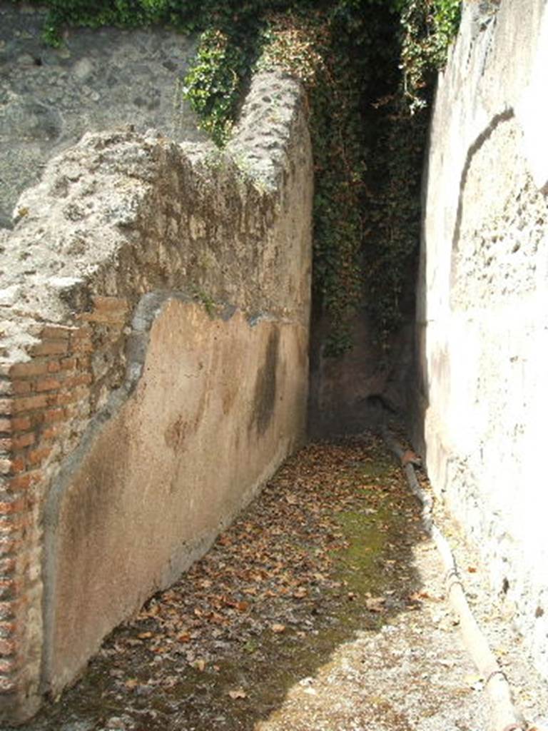 VII.1.17 Pompeii. May 2005. Corridor 12, leading to apodyterium 11 of women’s baths.
On the floor, running along the side of the corridor can be seen a lead pipe.
