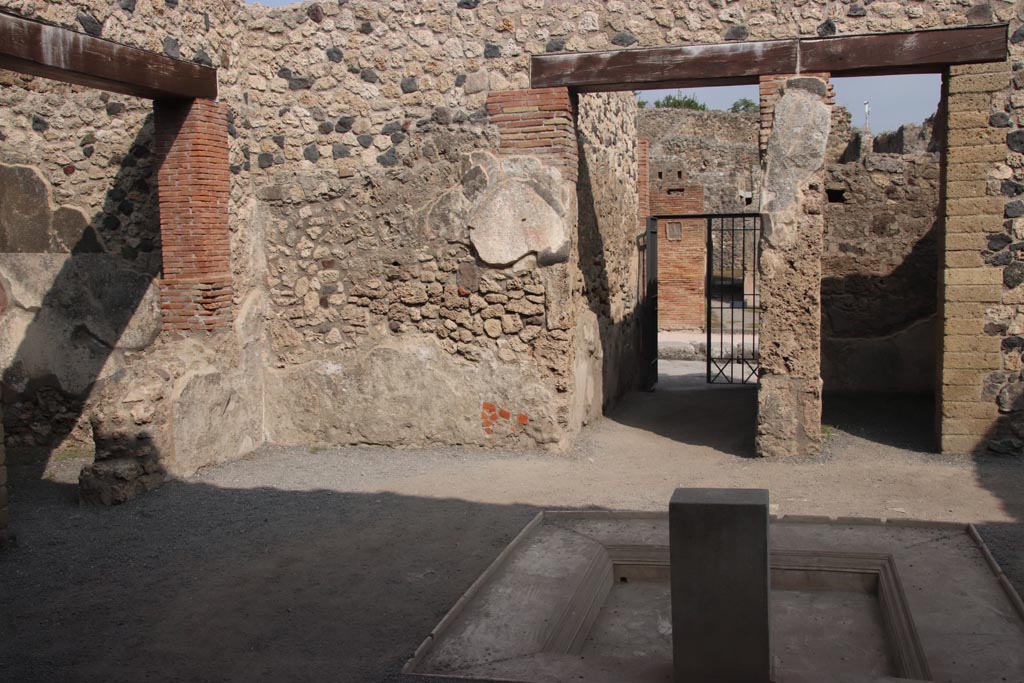 VII.1.25 Pompeii. May 2017. Looking east across atrium 24.  The corridor 23 to the entrance at VII.1.25 is on the left, followed by a doorway to a small room 25, centre, and doorway to room 26 in south-east corner of atrium.  The doorway to room 29 is to the right. Photo courtesy of Buzz Ferebee.

According to Fiorelli -
On the left, we find a cupboard, a storeroom with a painting of serpents, under which was the shelf to deposit the offerings, and the stairs to go up above: there we could read several graffiti, not least the acclamation NVMMIANO FELICITER  written in red, and written in carbon -
SIICVNDVS
RIIGIMONI
VIIII TIINIIT
FIILICITIIR
which now we can no longer see/read. There follows another cubiculum, and an ala.
(A sinistra trovansi un’apotheca, una cella penaria con la dipintura dei serpi, sotto cui lo sporto per depositarvi le offerte, e la scaletta per montare di sopra: vi si leggevano varie eipigrafi graffite, nonche l’acclamazione NVMMIANO FELICITER scitta in rosso, e col carbone –
SIICVNDVS
RIIGIMONI
VIIII TIINIIT
FIILICITIIR
che ora piu non si vede. Seguono un altro cubicolo, ed un’ ala.) 
See Pappalardo, U., 2001. La Descrizione di Pompei per Giuseppe Fiorelli (1875). Napoli: Massa Editore. (p.76)


