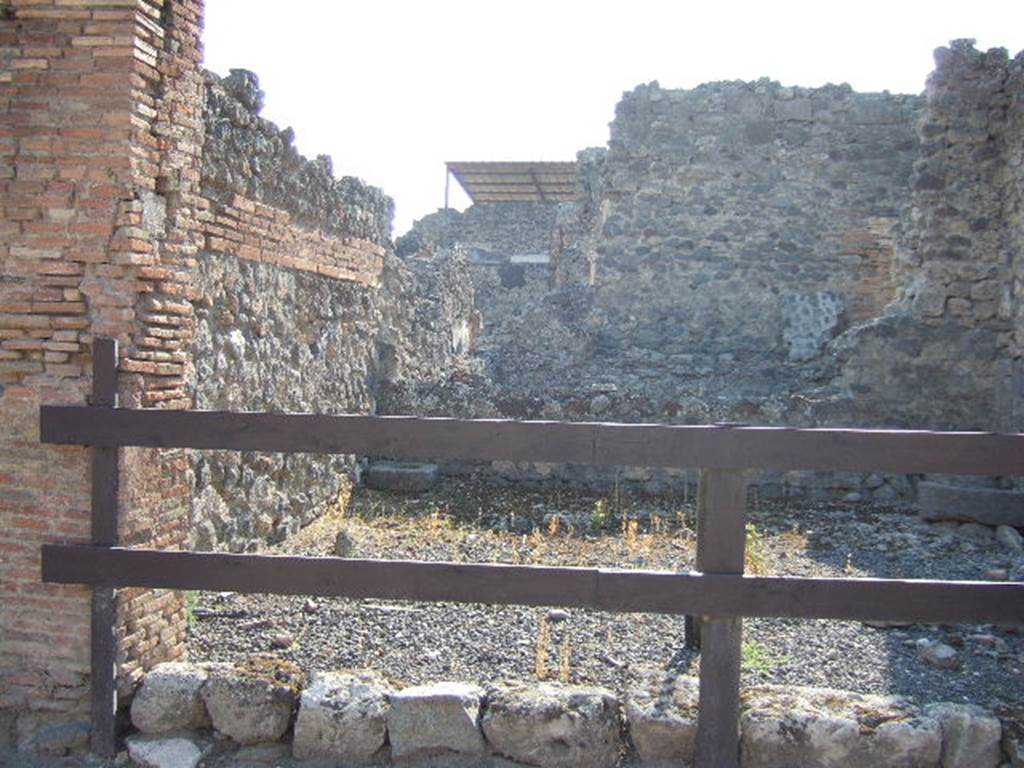 VII.1.28 Pompeii. September 2005. South side of shop, with one cistern mouth visible in south-west corner. There is another cistern mouth visible on the right of the photo.
