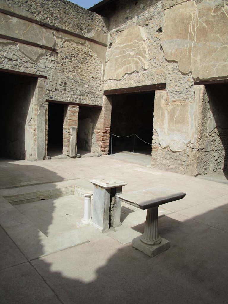VII.1.25 Pompeii. April 2018. Looking north-west across atrium 3.
On the left is the east end of the entrance corridor, then the two doorways belong to the room on west side of atrium.
The doorway to Exedra 10 can be seen on the left of centre.
The doorway on the right leads into the corridor to the kitchen area in VII.1.46.
Photo courtesy of Ian Lycett-King. 
Use is subject to Creative Commons Attribution-NonCommercial License v.4 International.

