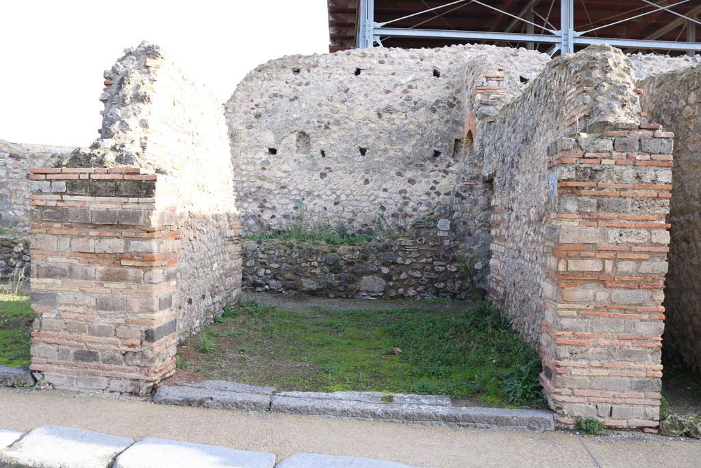 VII.1.57, Pompeii. December 2018. 
Looking east to entrance doorway, and low east wall in front of, at least two storey east side of wall, (?) belonging to Stabian Baths. 
Photo courtesy of Aude Durand.


