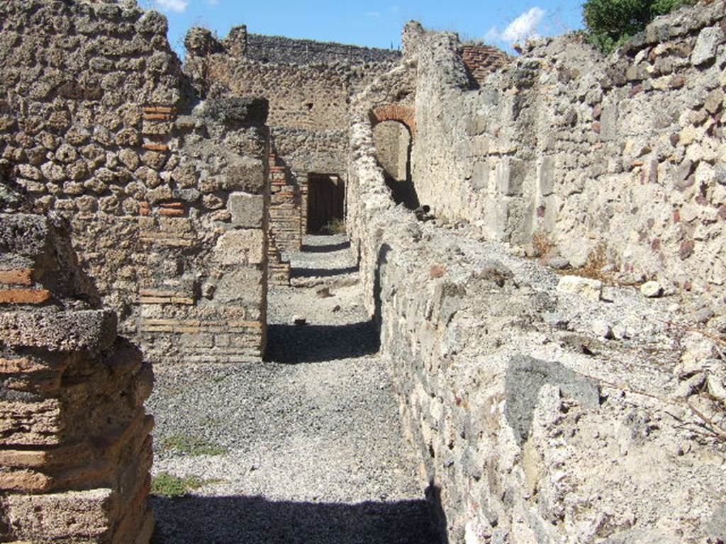 Corridor at rear of shops VII.1.52-VII.1.57 with Stabian Baths at rear. 
Looking north from end of entrance of VII.1.58, Pompeii. September 2005.
