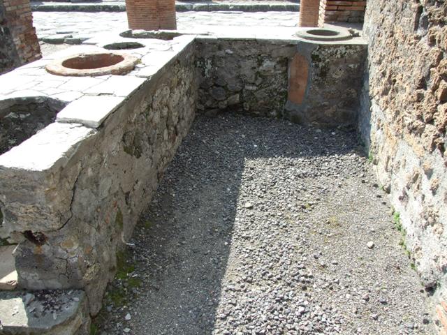 VII.4.4 Pompeii. March 2009.  Looking west towards Via del Foro, from rear of counter with hearth on its eastern end.
