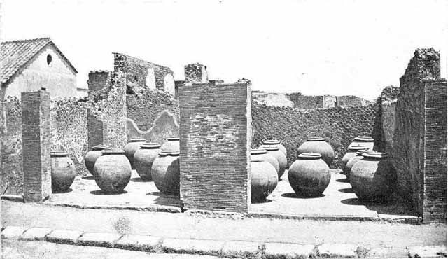 VII.4.13 and VII.4.14.    Via Foro oil shop.  Old undated photograph courtesy of the Society of Antiquaries, Fox Collection. Fiorelli says the two adjacent large shops had these Dolia temporarily deposited in them.  
They had come from outside Pompeii near “il Sarno”.  Some of these are now to be found outside the city wall below the Temple of Venus and the Sarno Baths.  See Pappalardo, U., 2001. La Descrizione di Pompei per Giuseppe Fiorelli (1875). Napoli: Massa Editore. (p.89).