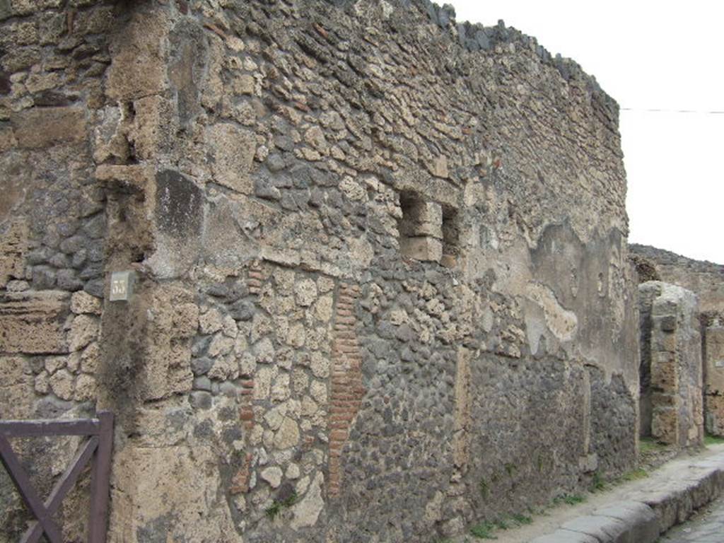 Street wall between VII.4.33 on left and VII.4.34 right, Pompeii. May 2006.
