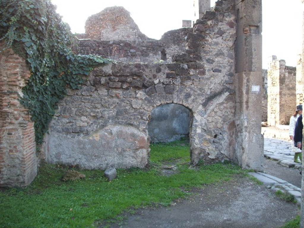 VII.4.46 Pompeii. December 2004. West wall with arched doorway to VII.4.47
