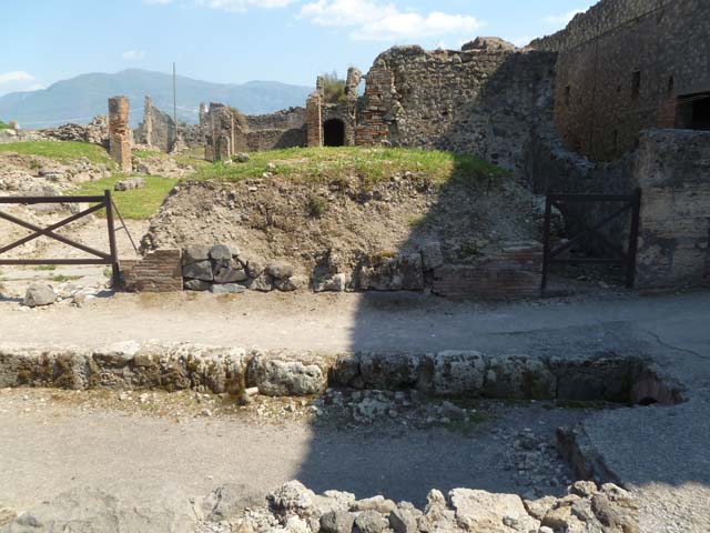 VII.6.2 and 1 Pompeii. May 2011. Looking south towards entrance doorways. The entrance to the bar at VII.6.2 would have been between the brick pillars visible near the pavement.
The entrance has been infilled. Photo courtesy of Michael Binns.
