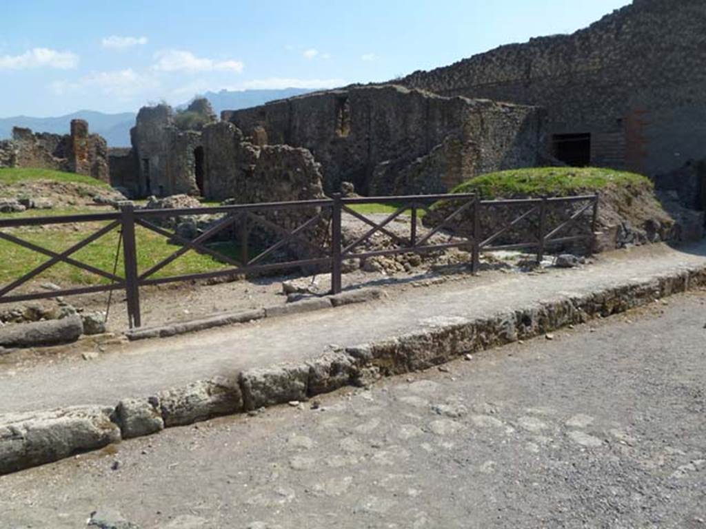 VII.6.5/4/3 Pompeii. May 2011. Looking south-west towards sites of doorways on Via delle Terme. On the left is the thicker base-stone of the steps to the upper floor at VII.6.5.
In the centre is a wider doorway to the shop at VII.6.4. The room on the right of the stone dividing wall would have been part of VII.6.3. On the right the bar at VII.6.2/1 can be seen.
Photo courtesy of Michael Binns.
