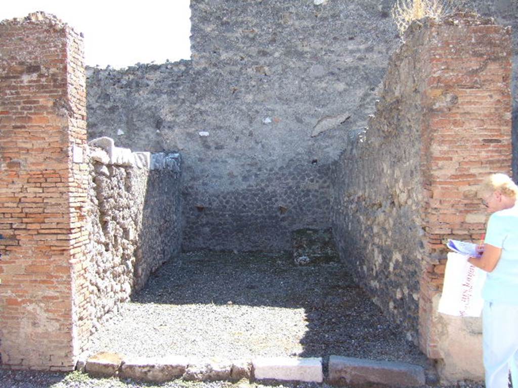 VII.9.16 Pompeii. September 2005. Looking south across entrance doorway.  In the south-west corner, on the right at the rear, can be seen the base of steps to upper floor.

