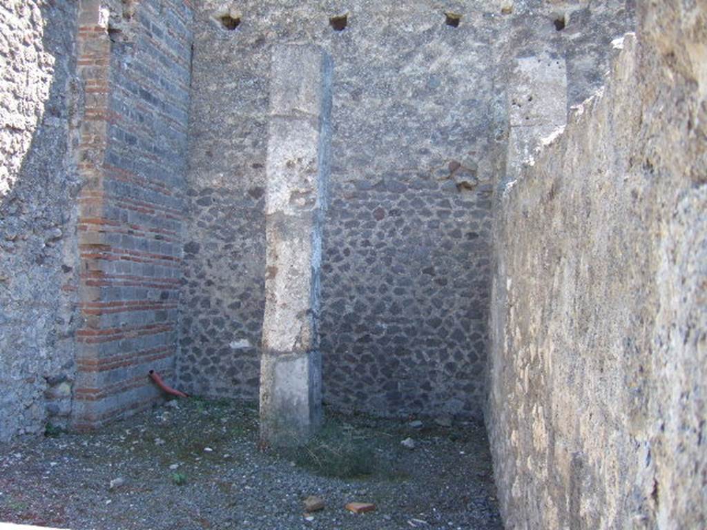 VII.9.23 Pompeii. September 2005. Limestone pillar on south side at rear of shop.