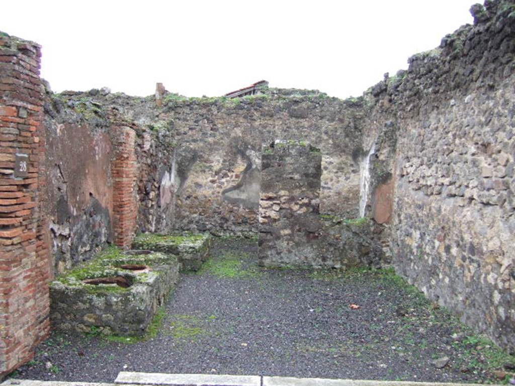 VII.9.28 Pompeii. December 2005. Looking south, on the left is a masonry counter with 3 urns against the east wall.  At the rear of the counter is a water basin and doorway to the rear room with a window in its north wall, on the right.
