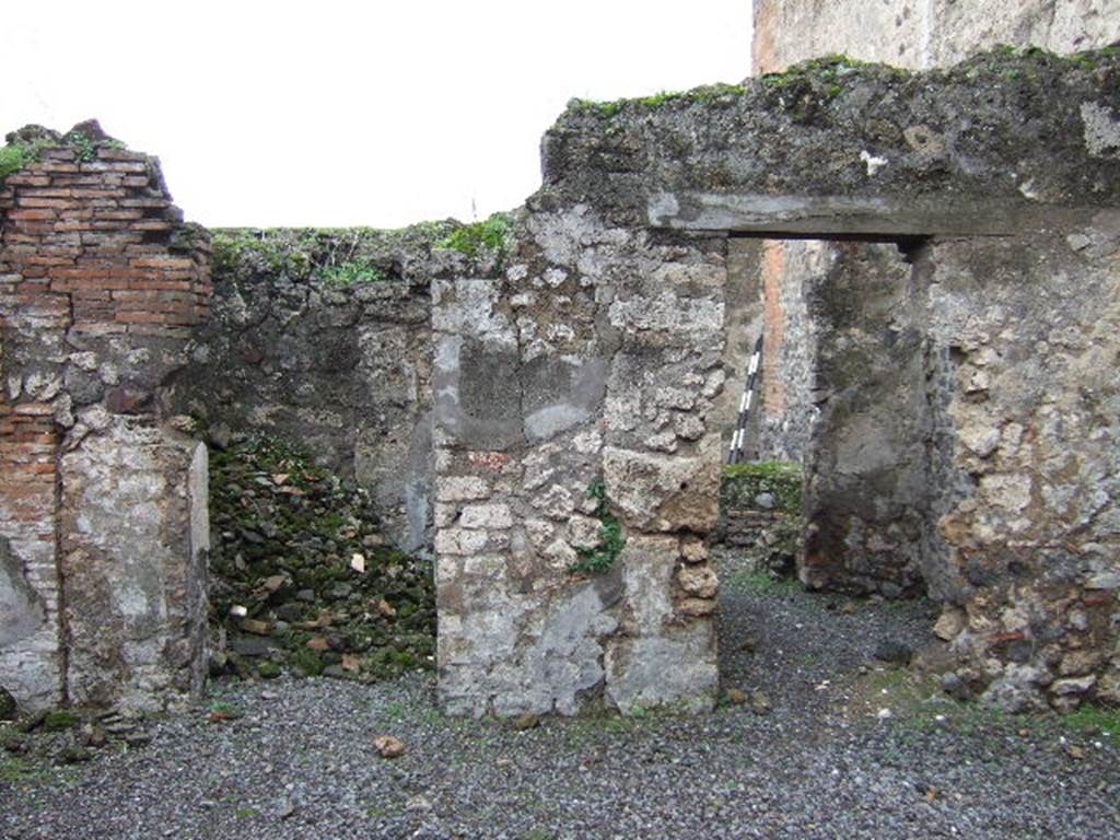 VII.9.40 Pompeii. December 2005. Two doorways to rooms on south side of atrium. On the left the doorway to a cubiculum. On the right, a doorway looking south into room with steps to upper floor, linking to workshop at VII.9.41.
