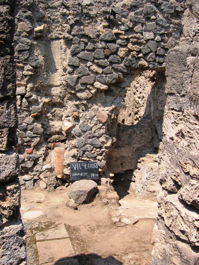 VII.9.63 Pompeii. July 2005. Looking west towards latrine. Photo courtesy of Barry Hobson.
According to Hobson, the original latrine was at the end of a narrow corridor to the north of the house. Probably in the first century, this latrine was sealed over and replaced by a latrine in the room immediately to the left of the doorway. This room might then have become a work area and perhaps housed the kitchen as well as the toilet.  Next door to VII.9.63 a new entrance from the street was made, giving access via a staircase to the upper storey, and to the right of the stairs another new latrine was constructed.  This was now back to back with the one in VII.9.63 and emptied into the same cesspit. In addition the staircase led to an upper storey latrine, the down pipe from which was inserted into the wall. The provision here of three latrines leads one to ask who used each of them?.  
See Hobson, B., 2009. Latrinae et foricae: Toilets in the Roman World. London; Duckworth. (p.68)
