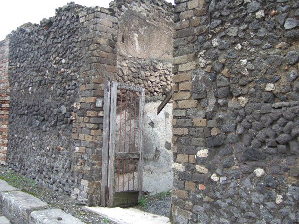VII.10.3 Pompeii. December 2005. Entrance doorway, with roughly hewn white travertine threshold. The socket for the housing of the hinges and for the fixing of the battens for the closure of the double doors could be seen. 
Studi della Soprintendenza archeologica di Pompei, 22: l”Insula VII, 10 di Pompei , by Angelo Amoroso. (p.53) 
