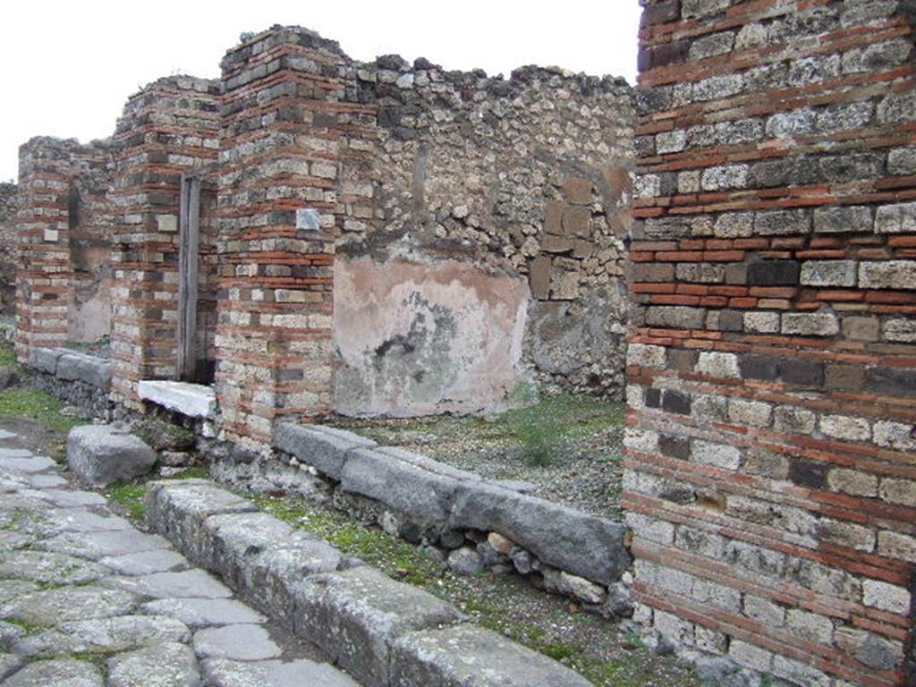 VII.10.4 Pompeii. December 2005. Entrance doorway, looking north along Vicolo di Eumachia. The threshold of the shop was made of lavastone. In the middle, the hollow for inserting the wooden planks of closure can be seen.
