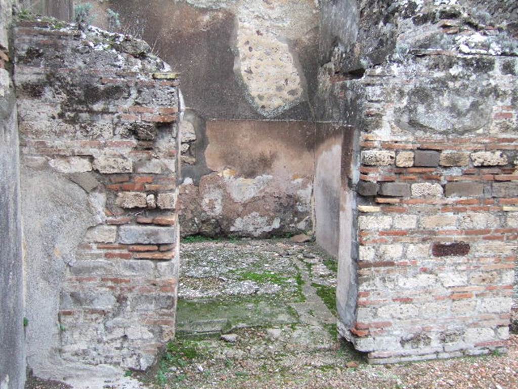 VII.10.5 Pompeii. December 2005. Doorway to cubiculum in north-west corner of atrium. 
According to Amoroso, in the surface of the floor of this room and preserved in situ is the only shaped tufa of Nocera block, belonging to the previous impluvium. (p.80) 
Studi della Soprintendenza archeologica di Pompei, 22: l”Insula VII, 10 di Pompei , by Angelo Amoroso. (p.80)
According to Bragantini et al, the flooring in this room was cocciopesto with scattered chippings of black and white tesserae. The plastered walls had a high protruding zoccolo of cocciopesto, the middle zone was still rough plaster.
See Bragantini, de Vos, Badoni, 1986. Pitture e Pavimenti di Pompei, Parte 3. Rome: ICCD. (p.182)
