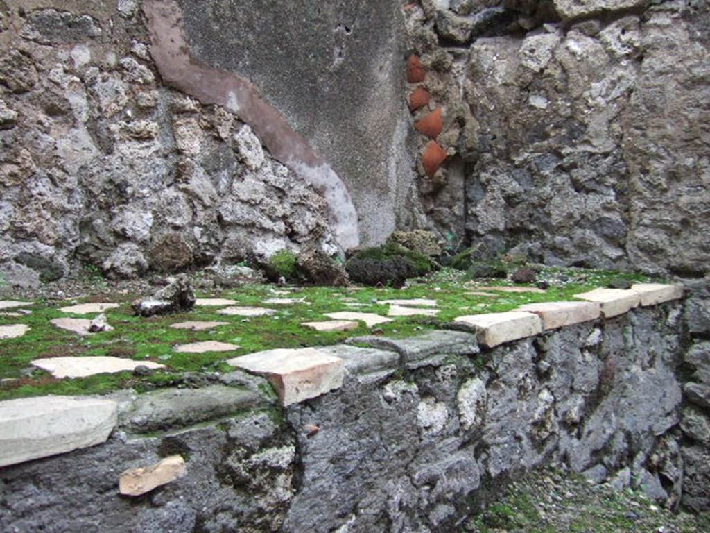 VII.10.8 Pompeii. December 2005. Hearth or bench on east side of doorway in kitchen area. 
