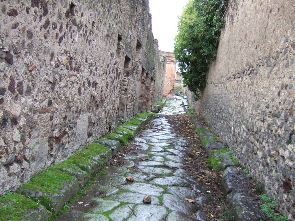 VII.13 Pompeii, on left. December 2005.         Vicolo degli Scheletri looking west.                 Side wall of VII.10.14, on right.